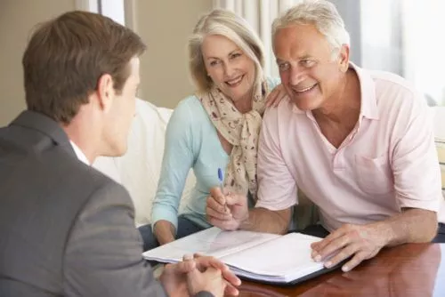 Elderly couple signing a document